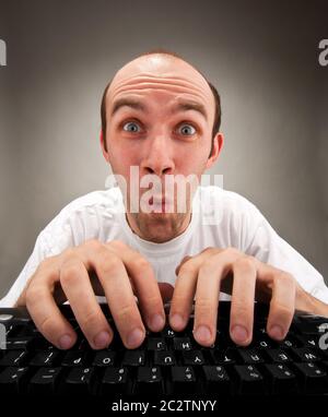 Very surprised funny nerd working on computer Stock Photo