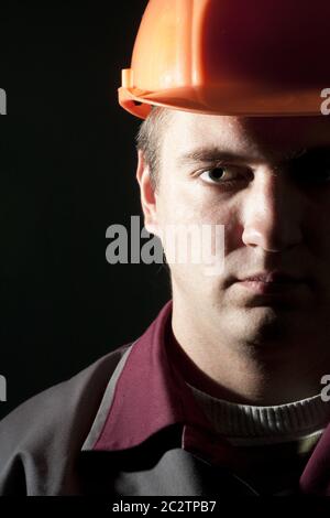 Portrait of serious builder in workwear and helmet Stock Photo