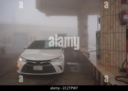 Abha / Saudi Arabia - January 23, 2020: Car in dense fog in petrol station at the Asir mountains near Abha, Saudi Arabia Stock Photo