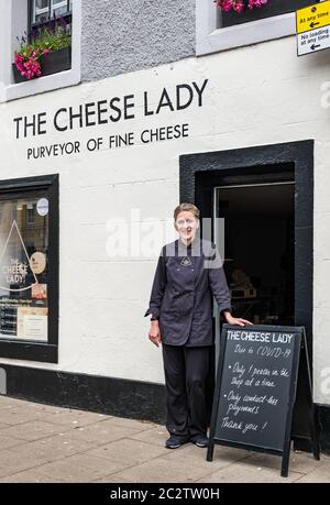 Haddington, East Lothian, Scotland, United Kingdom, 18th June 2020. Businesses re-opening: as lockdown restrictions ease, local businesses can reopen. The Cheese Lady, aka Svetlana Kukharchuk, is the smallest shop in the market town and can only fit one customer in at a time. The shop has been making home deliveries since the start of the lockdown but re-opened last Saturday and is now open 3 days a week. The shop owner outside her cheesemonger shop, a purveyor of fine and artisan cheeses, with a notice about Covid-19 measures for social distancing and contactless payments Stock Photo