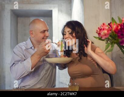 Man and woman eating bolognese spaghetti in restorant Stock Photo