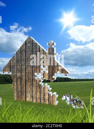 House consisting of wooden puzzles on the beautiful meadow Stock Photo