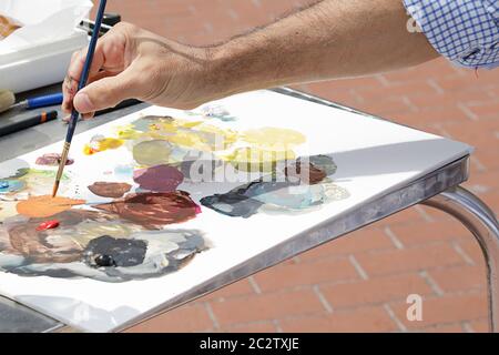 A painter using paint utensils (oil paint, artist brush) Stock Photo