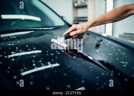 Specialist prepares car for protect against chips and scratches. Paint protection. Protective coating Stock Photo