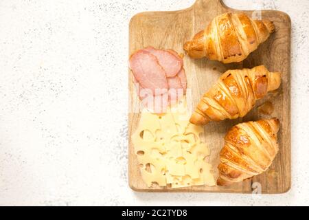 breakfast with croissants. fresh crispy croissants and coffee on a light  background, top view/ Stock Photo