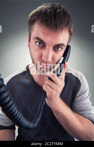 Bored young businessman talks on phone Stock Photo