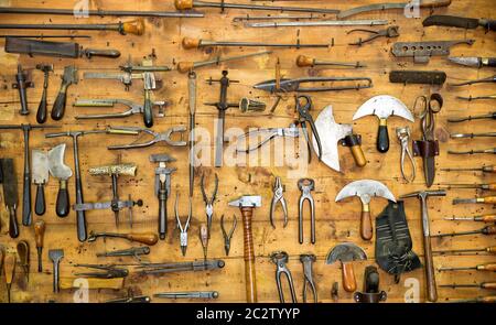 Various old tools on the wall in leather craft workshop Stock Photo