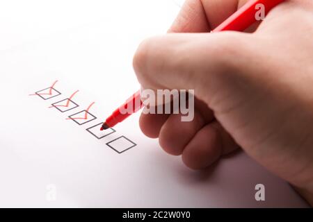 Hand with pen and check boxes on white background Stock Photo