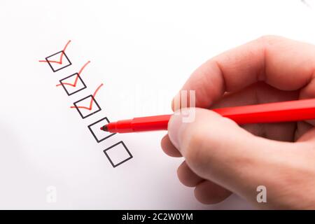 Hand with pen and check boxes on white Stock Photo