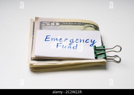 Black Paper Clip With Folded Fifty Dollar Banknote And Emergency Fund Text On Paper Stock Photo