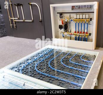 Floor heating distributor, exhibition sample in the store. Mounting or installation scheme, warm house control Stock Photo