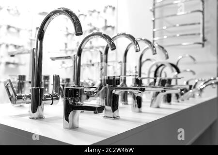 Rows of new chrome faucets in plumbing shop, closeup, nobody. Sanitary equipment Stock Photo