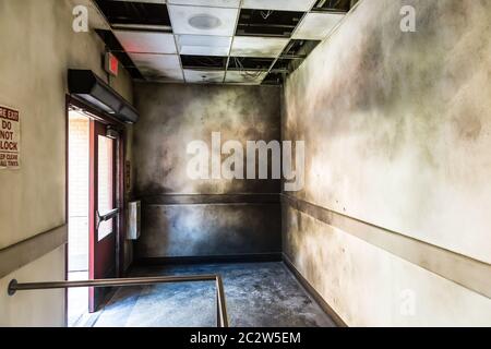 Gloomy burned hall and opened fire exit. Cinema set decoration. Stock Photo