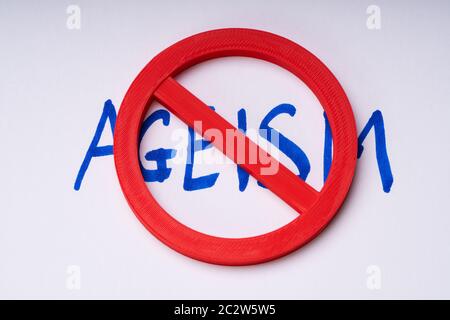Red Stop Sign On Handwritten Ageism Text Over White Backdrop Stock Photo