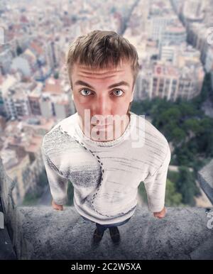Funny man standing on the edge of the building Stock Photo