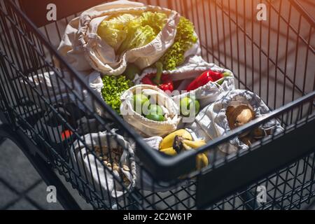 set of reusable and zero waste cotton shopping bags for food in cart Stock Photo