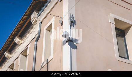 white CCTV surveillance camera on a stone wall Stock Photo