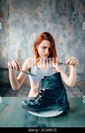 Fat or calories burning concept. Weight loss, anorexia illness. Unhappy skinny woman against plate with boot, absence of appetite. Stock Photo