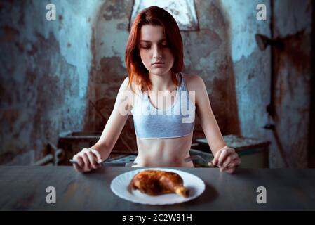 Unhappy skinny woman against plate with food, absence of appetite. Fat or calories burning concept. Weight loss, anorexia Stock Photo
