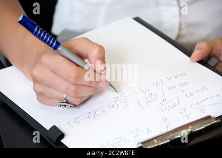 Student in classroom writing mathematics formulas Stock Photo