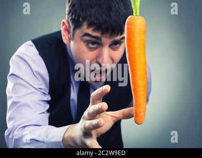 Bait metaphor. Man and carrot . Stock Photo