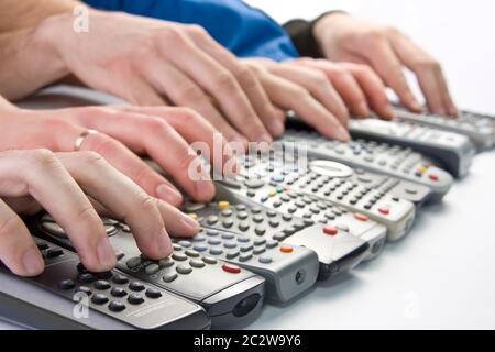 Remote controlers with many hands Stock Photo