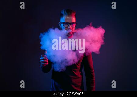 Vaping flavored e-liquid from an electronic cigarette Stock Photo