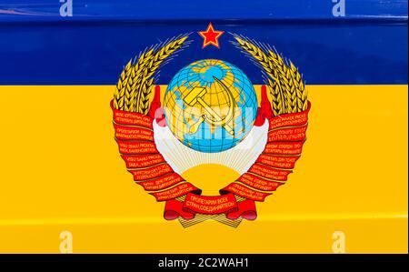 State emblem of the USSR over ukrainian flag Stock Photo