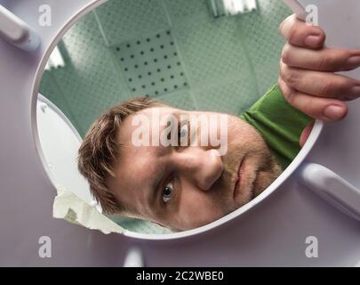 Man ready to puke in the bathroom in the toilet bowl Stock Photo