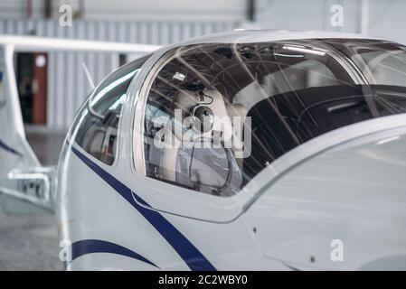 Small propeller plane in hangar, plane on inspection before flight. Private airline, air transportation, front view on turboprop airplane Stock Photo