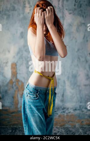Anorexic Girl Measures With The Tape Measure Her Tight Waistline