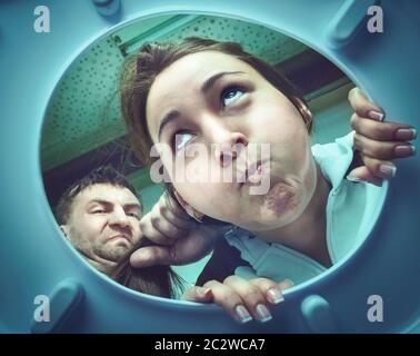 Man making woman puke in the bathroom in the toilet bowl Stock Photo