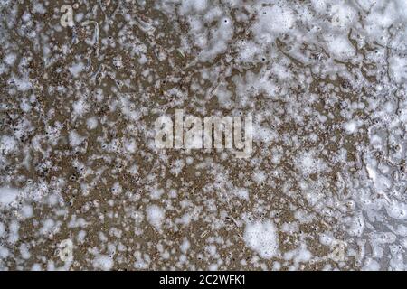 chaotic spray of soapy foam on a concrete dirty floor. abstract background Stock Photo