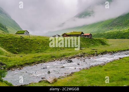 hut wooden mountain huts in mountain pass Norway. Norwegian landscape with typical scandinavian grass roof houses. Mountain vill Stock Photo