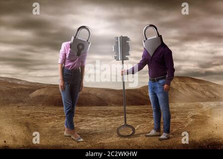 Man and woman with keyholes instead of heads holds big key, desert on background. Couple relationship concept, secret path to the heart Stock Photo