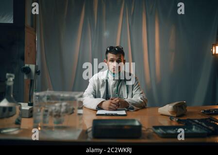 Male psychiatrist sitting at the table, mental hospital. Doctor in clinic for the mentally ill Stock Photo