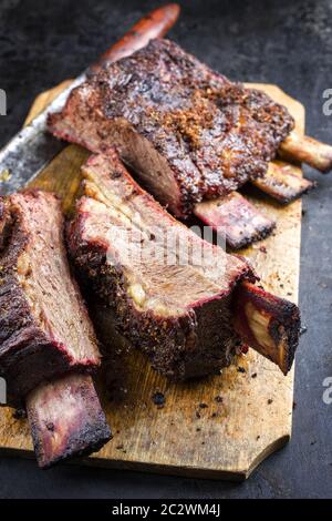 Barbecue chuck beef ribs with hot rub as closeup sliced on a wooden cutting board Stock Photo