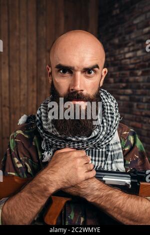 Cruel terrorist in uniform with kalashnikov rifle, male mujahadeen with weapon. Terrorism and terror, soldier in khaki camouflage Stock Photo