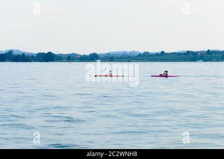 Two men canoeing on Lake Iseo in Italy Stock Photo
