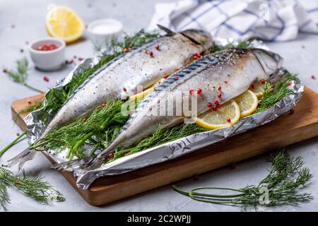 Raw mackerel on fresh dill with lemon slices. Stock Photo