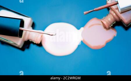 Bottles of nail polish spilled on a blue background Stock Photo