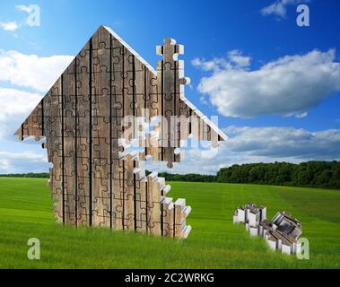 House consisting of wooden puzzles on the beautiful meadow Stock Photo