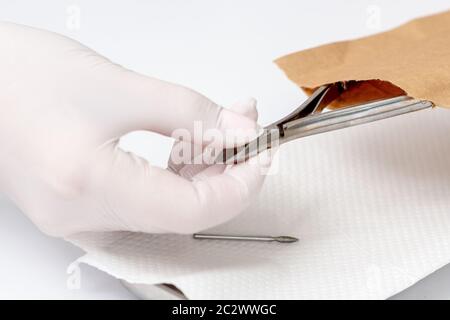Hands taking manicure tools from craft envelope before manicure procedure. Stock Photo