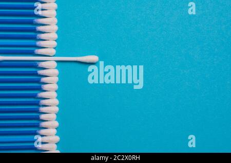 Ear sticks on a blue background. Medical sticks for smear. Sticks for cleaning ears lie in a row, on a blue background. Place for the text. opy space Stock Photo