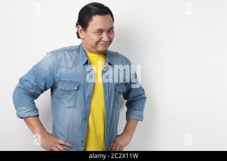 Headshot portrait of funny attractive young Asian man smiling flirty and thinking something naughty, close up headshot portrait Stock Photo