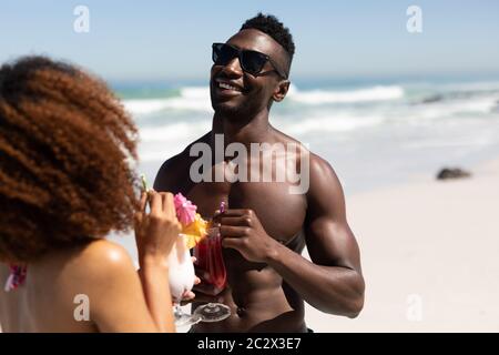 Mixed race couple drinking cocktails on the beach Stock Photo