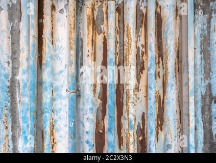 Old corrugated metal texture with rust spots on surface and peeled-off paint. Stock Photo