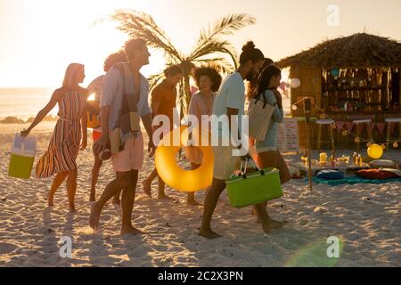 Mixed race friends group walking on beach Stock Photo