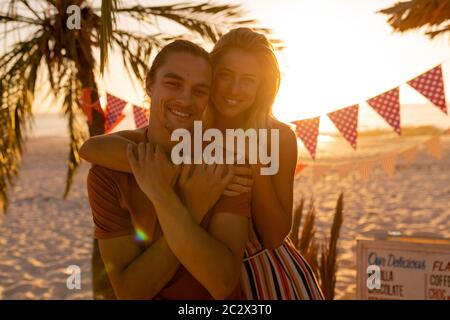 Caucasian friends hugging on beach Stock Photo