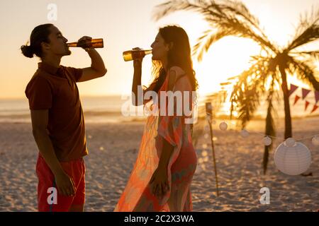 Caucasian couple drinking alcohol on beach Stock Photo